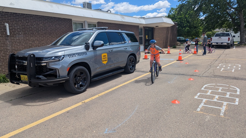 Second graders learning to ride their bikes around parked vehicles