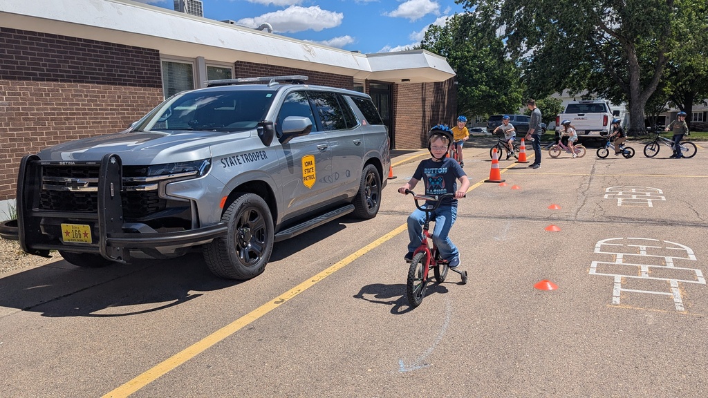 Second graders learning to ride their bikes around parked vehicles