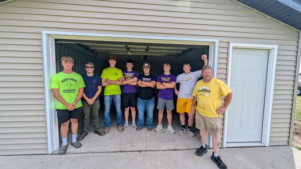 Building Trades students standing in the garage of the shed they built for the marching band