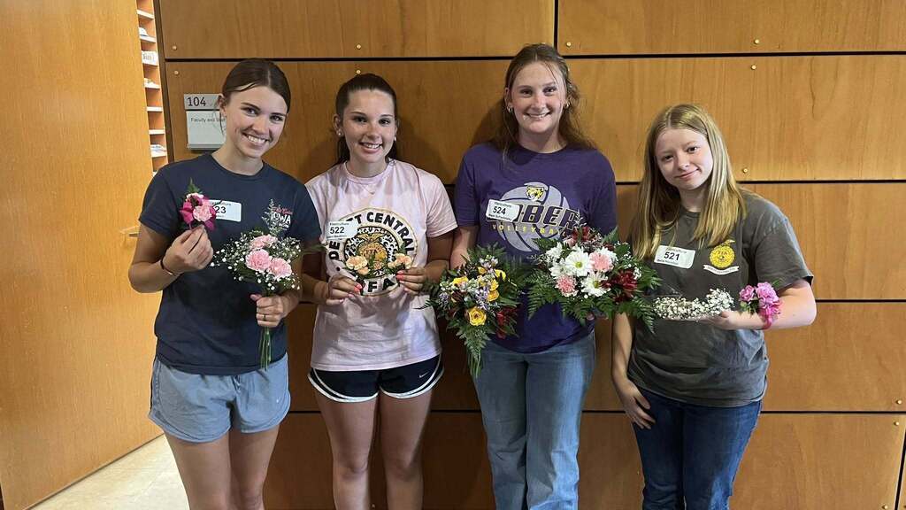 Emily Sutton, Dalani Beuthien, Megan Schladetzky, and Bella Houston showing their floral arrangements