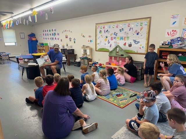 Clinton County Conservation reading a book to Saber Cubs