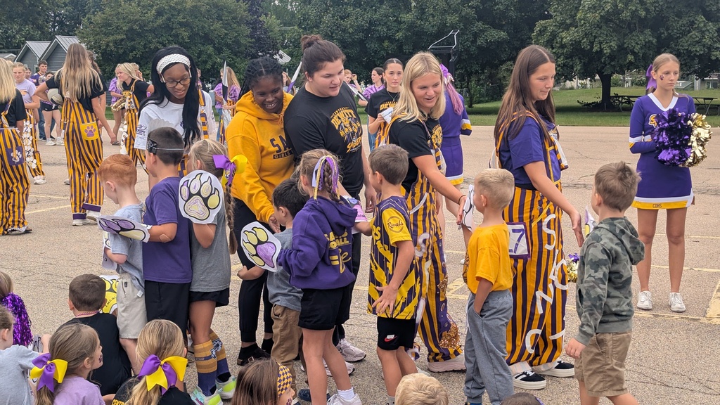Seniors at Ekstrand Elementary pep assembly giving high fives to kindergartners