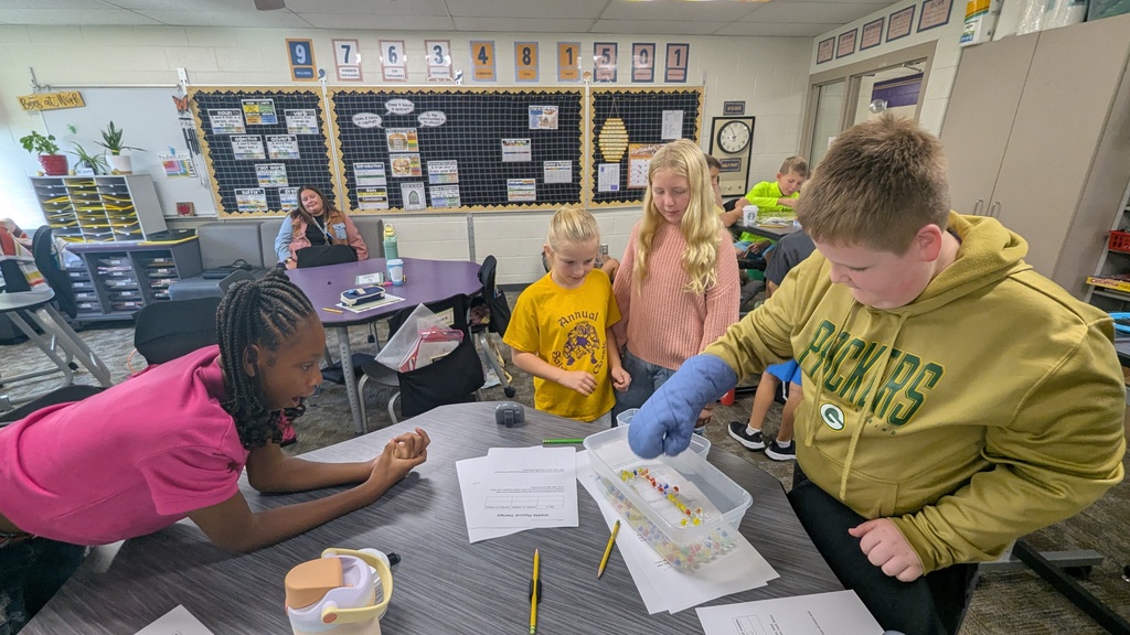 4th graders trying to pick up marbles while using an oven mitt