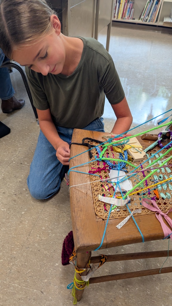 Art student tying their object to the chair as part of a collaborative work