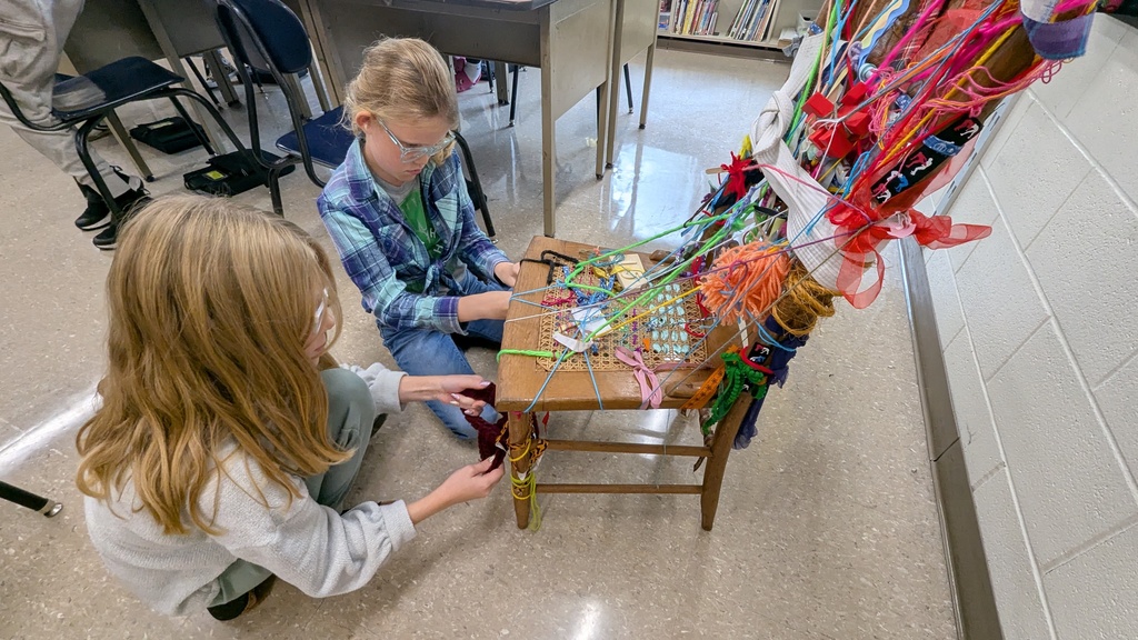 Art student tying their object to the chair as part of a collaborative work
