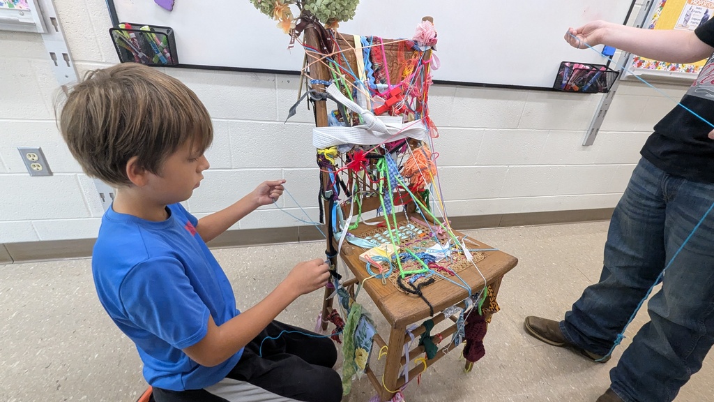 Art student tying their object to the chair as part of a collaborative work