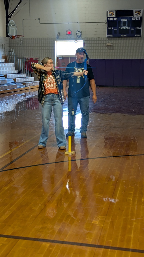 Mrs. Hamann using a bow and arrow