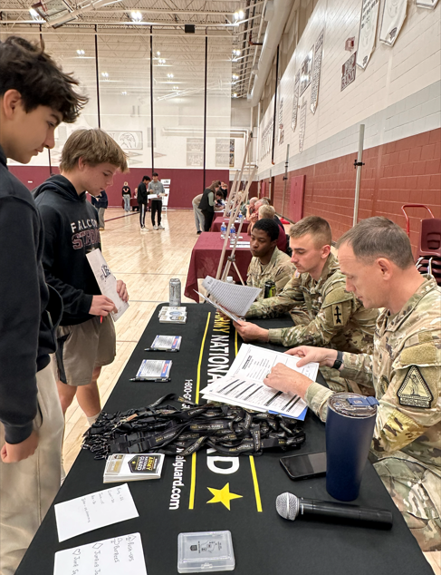Student at a table with volunteers