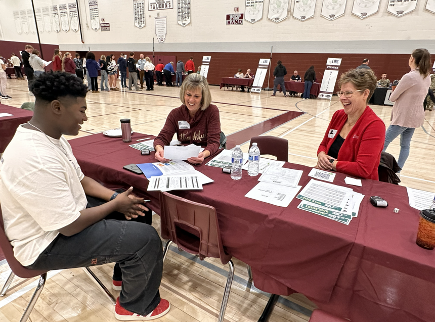 Student at a table with volunteers