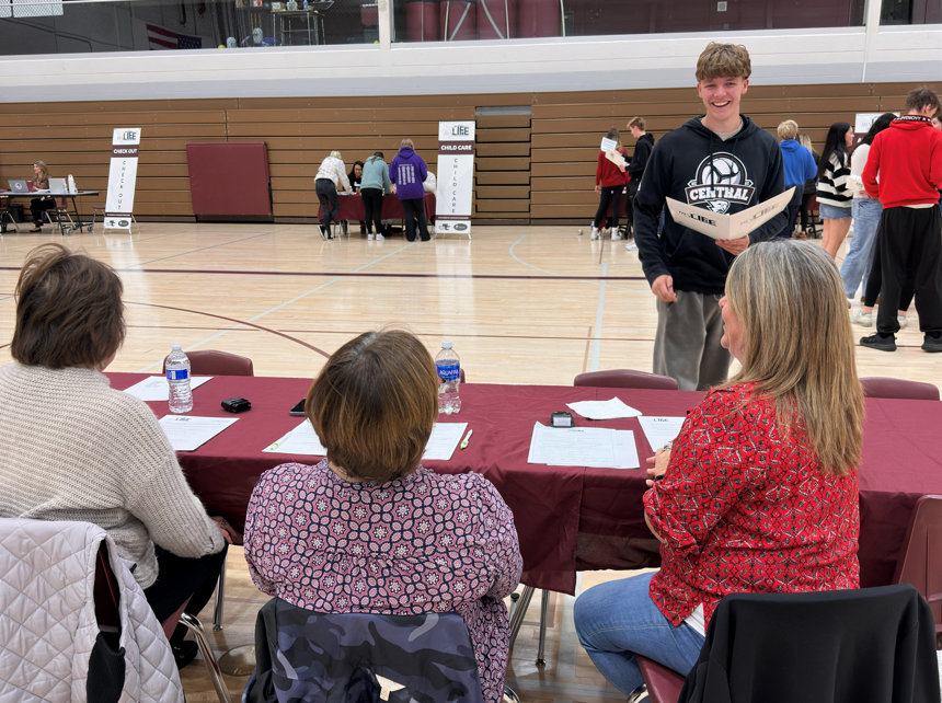 Student at a table with volunteers