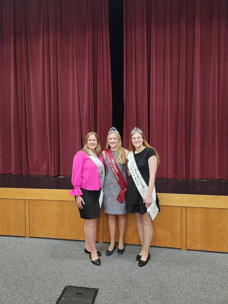 Three women standing in front of a stage