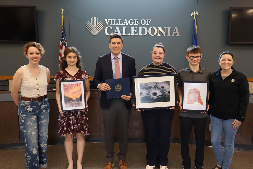 Group of students holding artwork