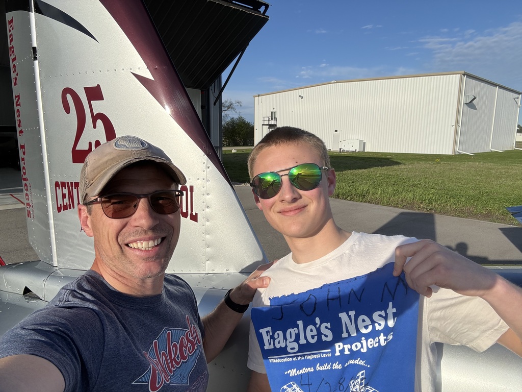 Student and mentor standing in front of plane