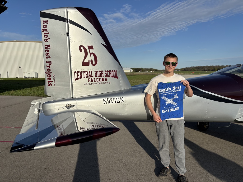 Student standing in front of plane