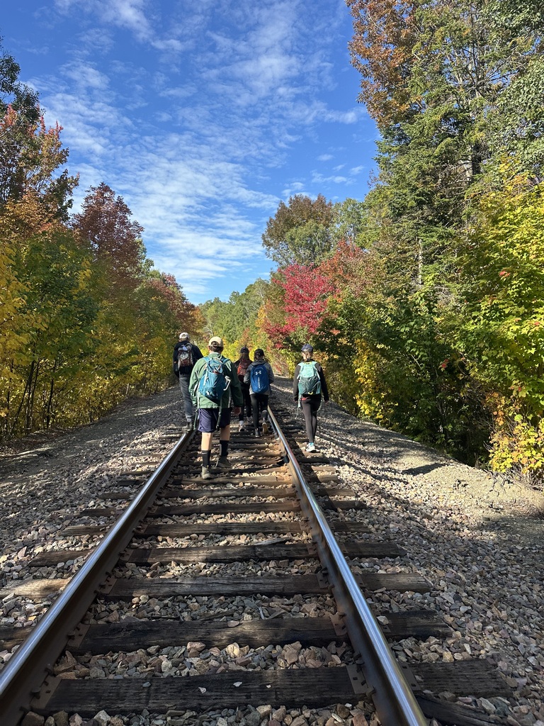 8th grade students walking the train tracks to the trail up sally mountain