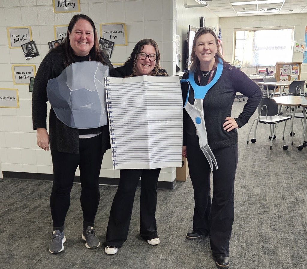 3 teachers dressed up ,one as a rock, one as a piece of paper, and one as a scissors.