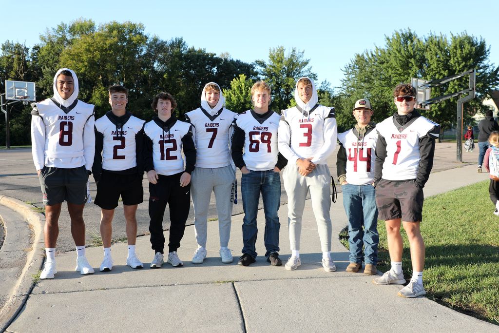 Senior football players posing for a pic outside the elementary school