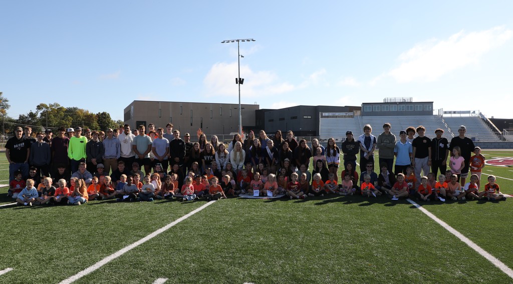 The Senior class and kindergarten class pose for a picture after they exchanged school spirit.