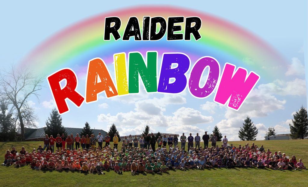 Elementary students in grades Pre-K-5th grade wearing colored shirts, sitting outside forming a rainbow to show their school spirit
