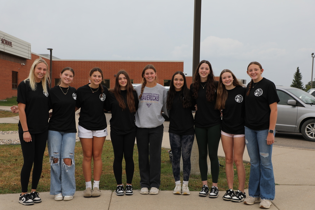 Varsity volleyball players smiling outside  the elementary school