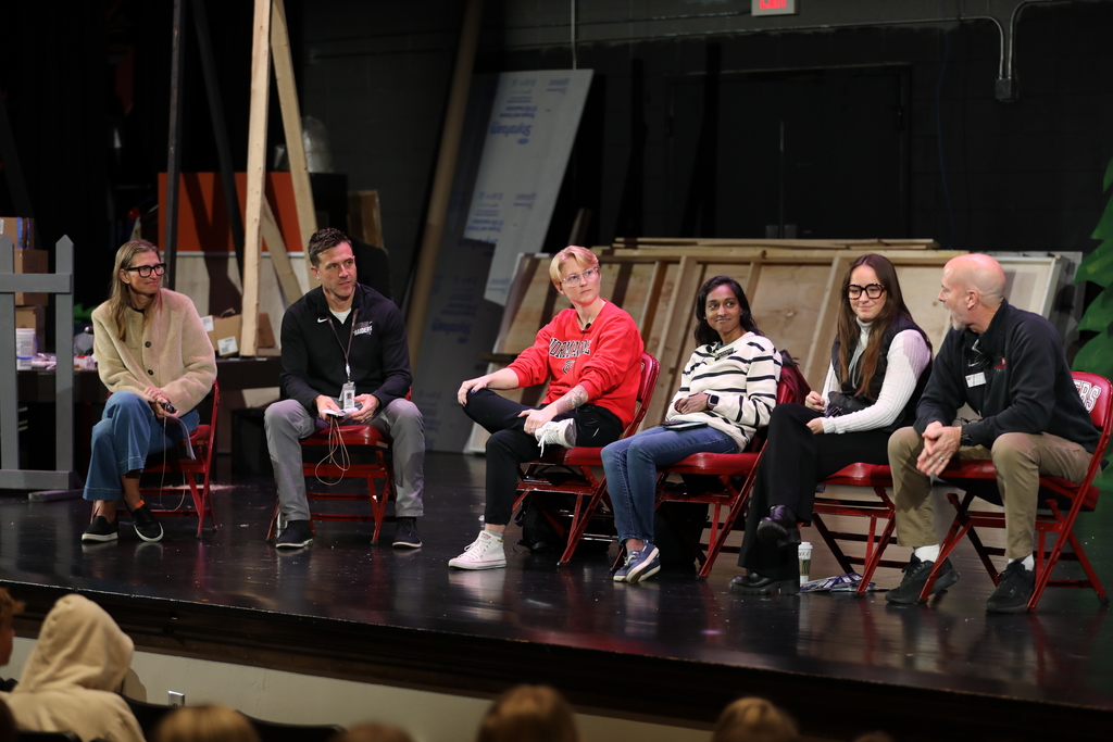 A group of college reps, the high school principal and guidance counselor, speak to high school students