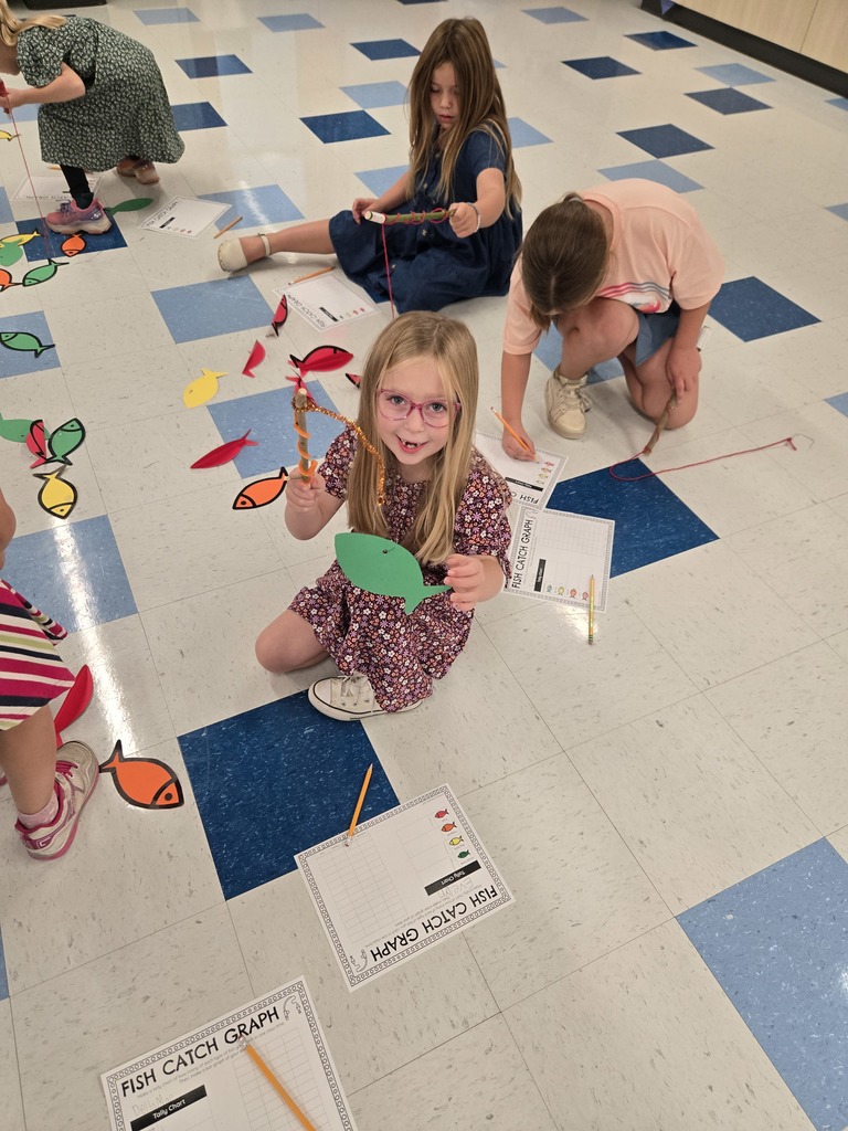 young students using sting and sticks to fish for paper fish