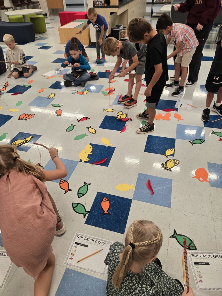 young students using sting and sticks to fish for paper fish