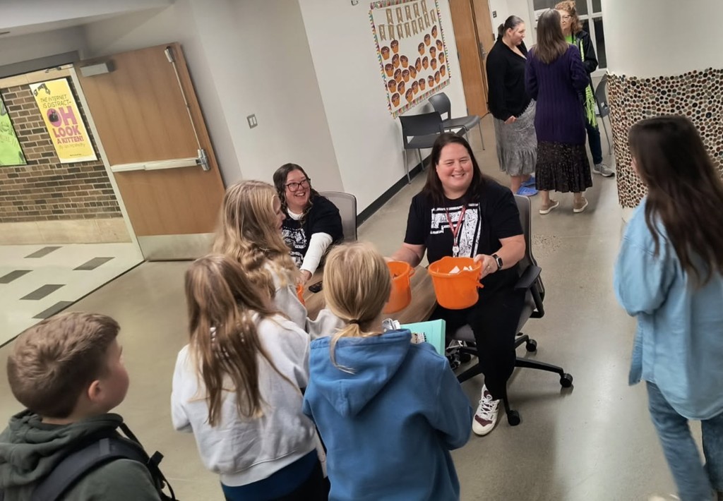 Two teachers handing out candy and inspirational messages
