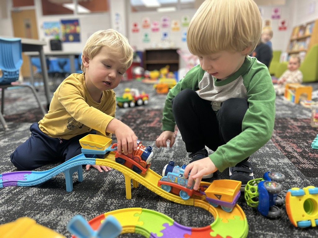 two young children playing trains together