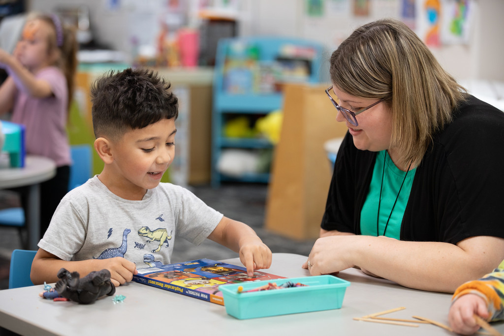 student and teacher looking at coloring book