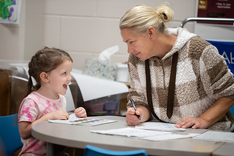 teacher smiling at student at desk