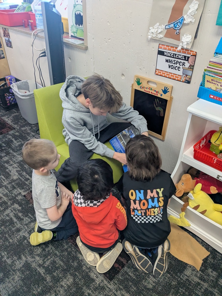 A middle school student reading to preschoolers