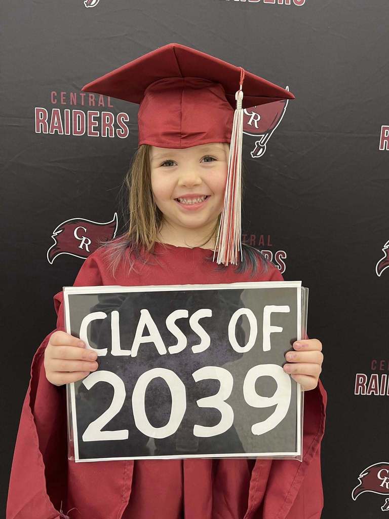 future kindergartener in cap and gown holding sign that says class of 2039
