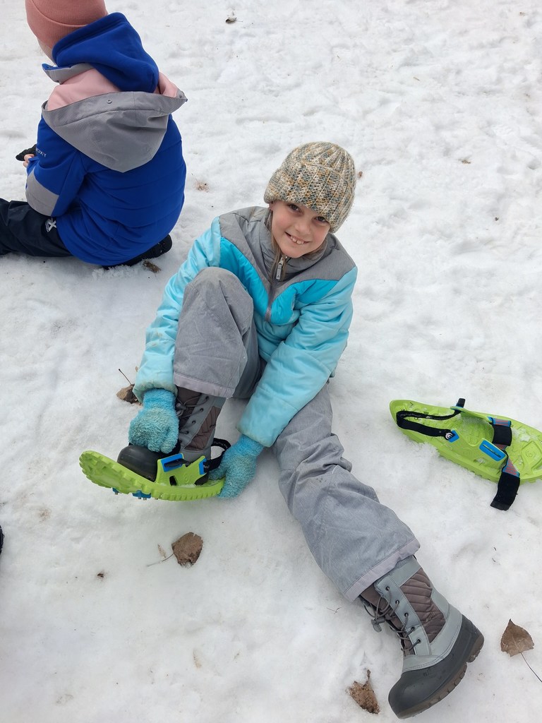 student putting on snowshoes