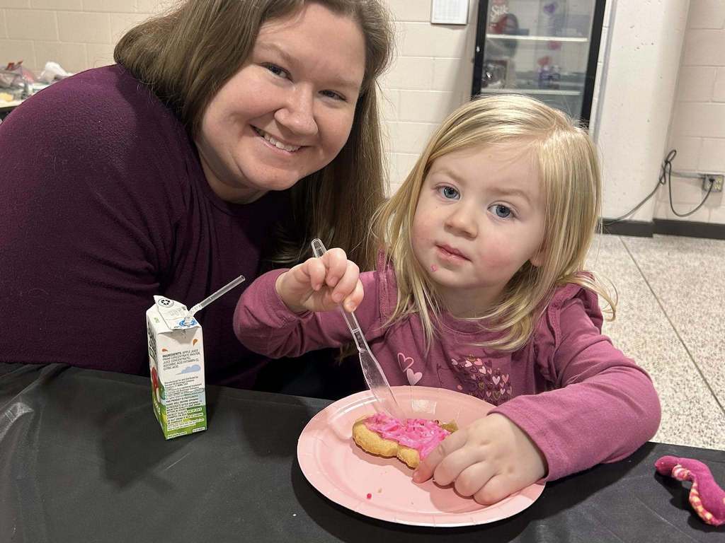 students and parents at sweetheart night decorating cookies
