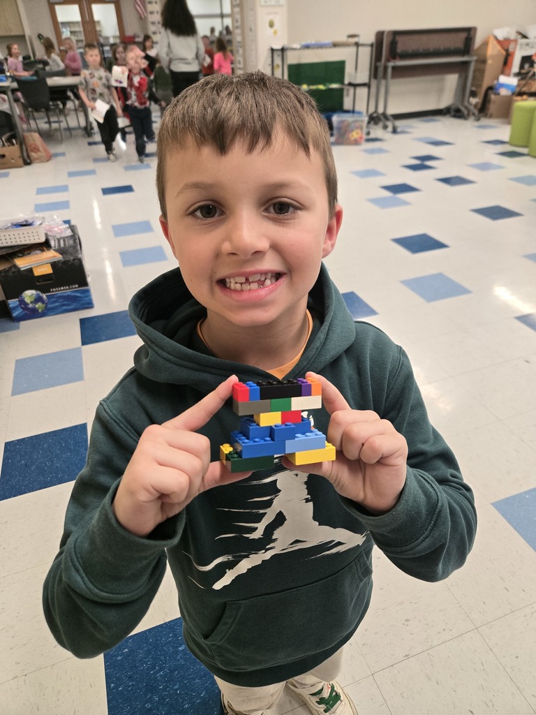 Student showing something he built with lego bricks