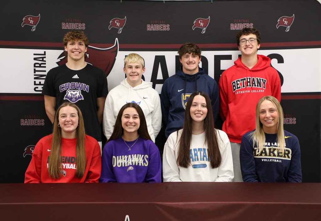 8 Seniors smiling after signing letters of intent to play college sports