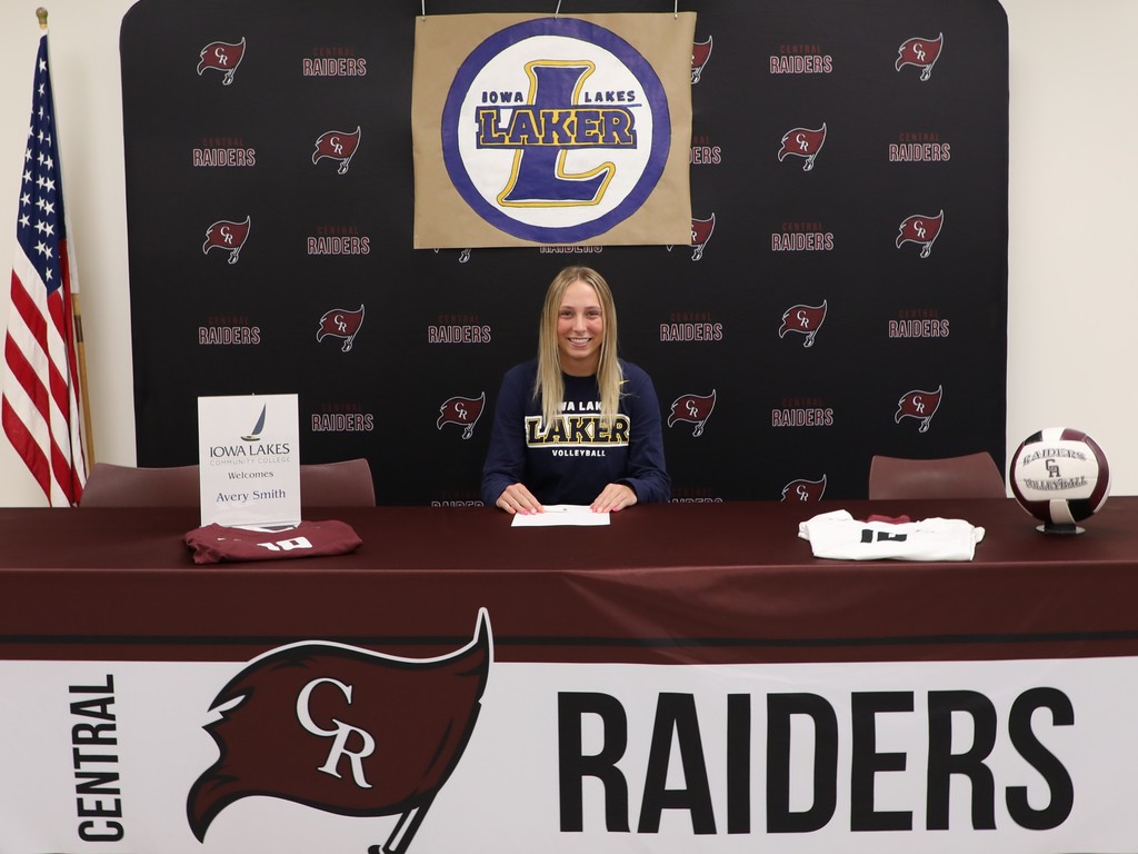 A high school senior smiling after signing to play volleyball in college