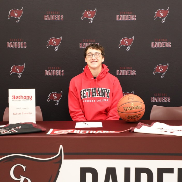 A high school senior smiling after signing to play college basketball