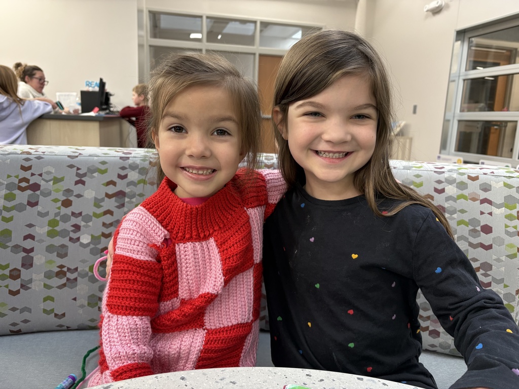 two kindergarteners smiling together on couch