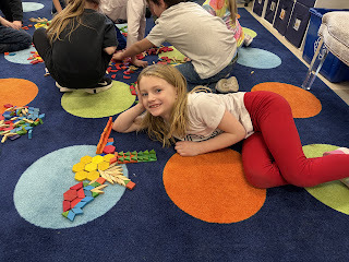 kindergarten student with shape blocks on the floor