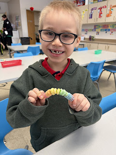 kindergarten student with fruit loops on a pipe cleaner