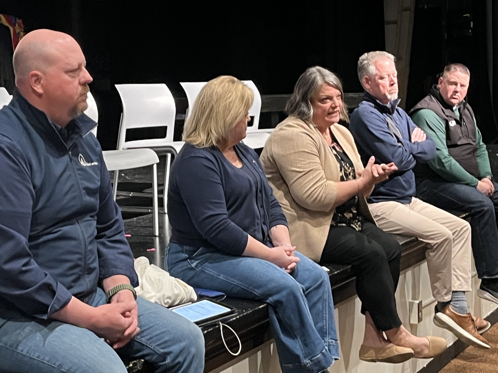 panel of speakers on auditorium stage