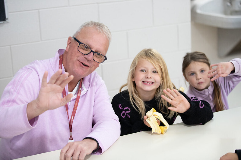 principal and students waving to camera