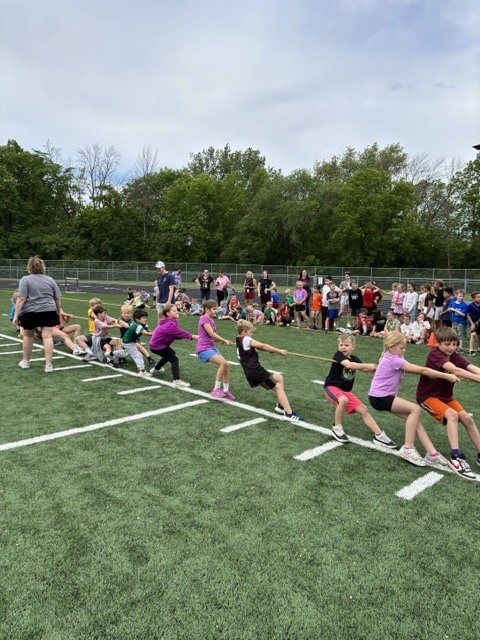 student tug of war on football field