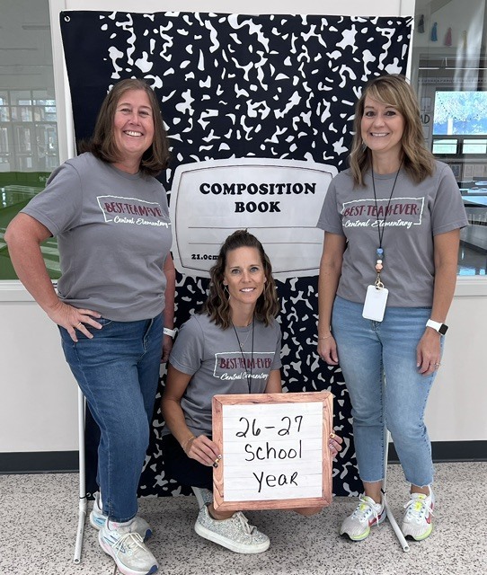 kindergarten teachers standing in front of notebook sign