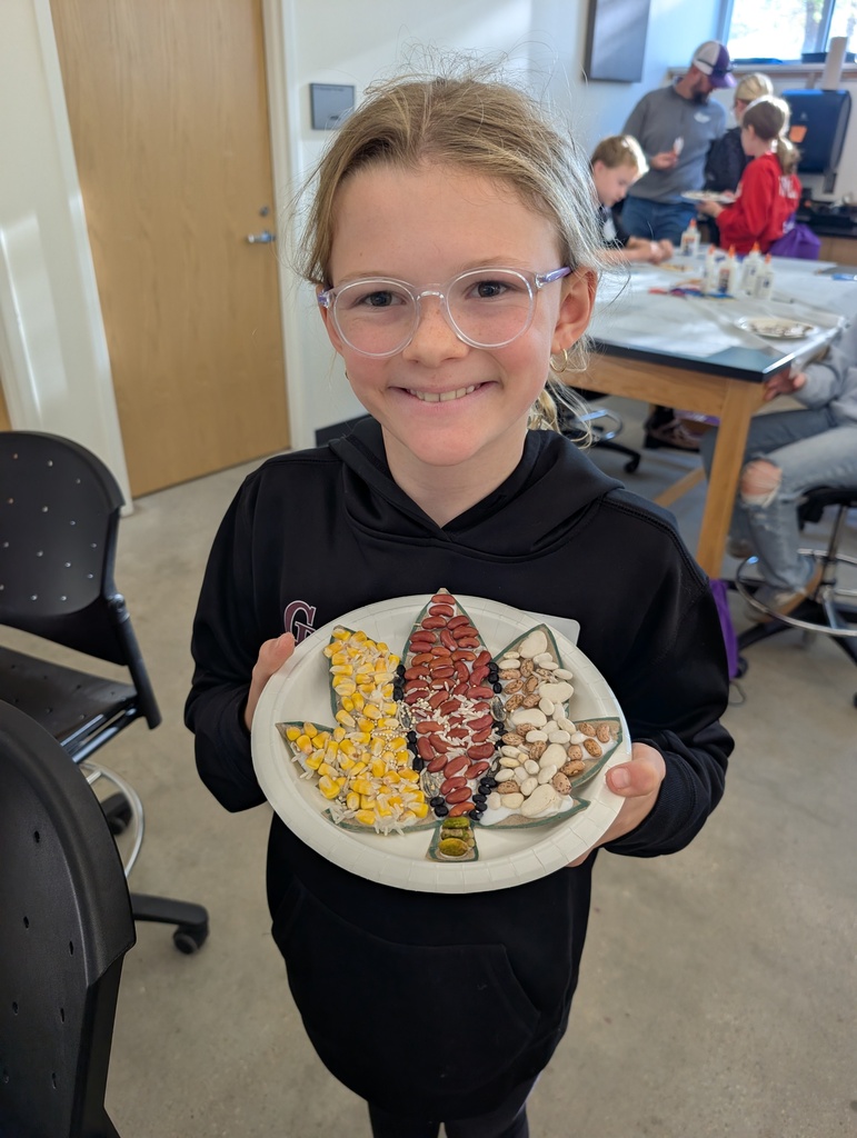 student holding fall leaf mosaic