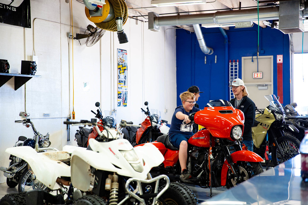 kid sits at red motorcycle