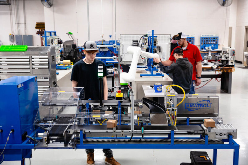 Students working with industrial automation equipment