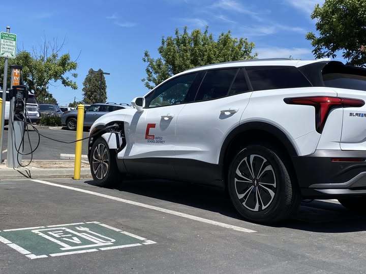White SUV with CUSD logo being charged